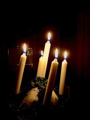 A girl in a white gown wearing the Lucia crown of lit candles